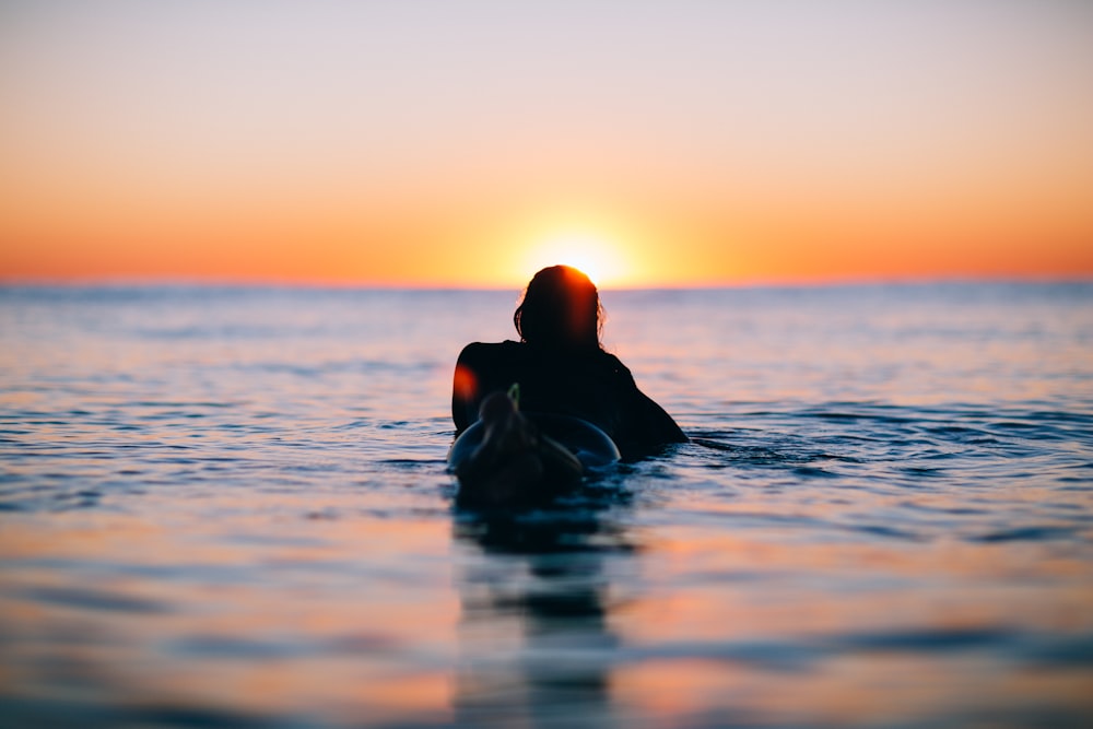 Hombre en el agua durante la puesta del sol