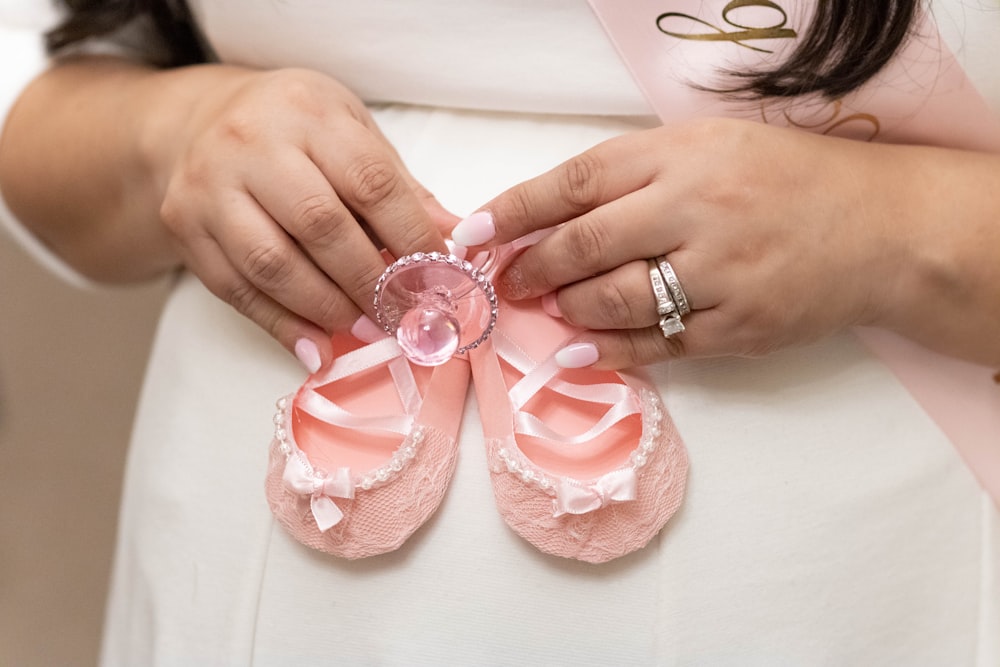 person holding pink and white heart shaped decors