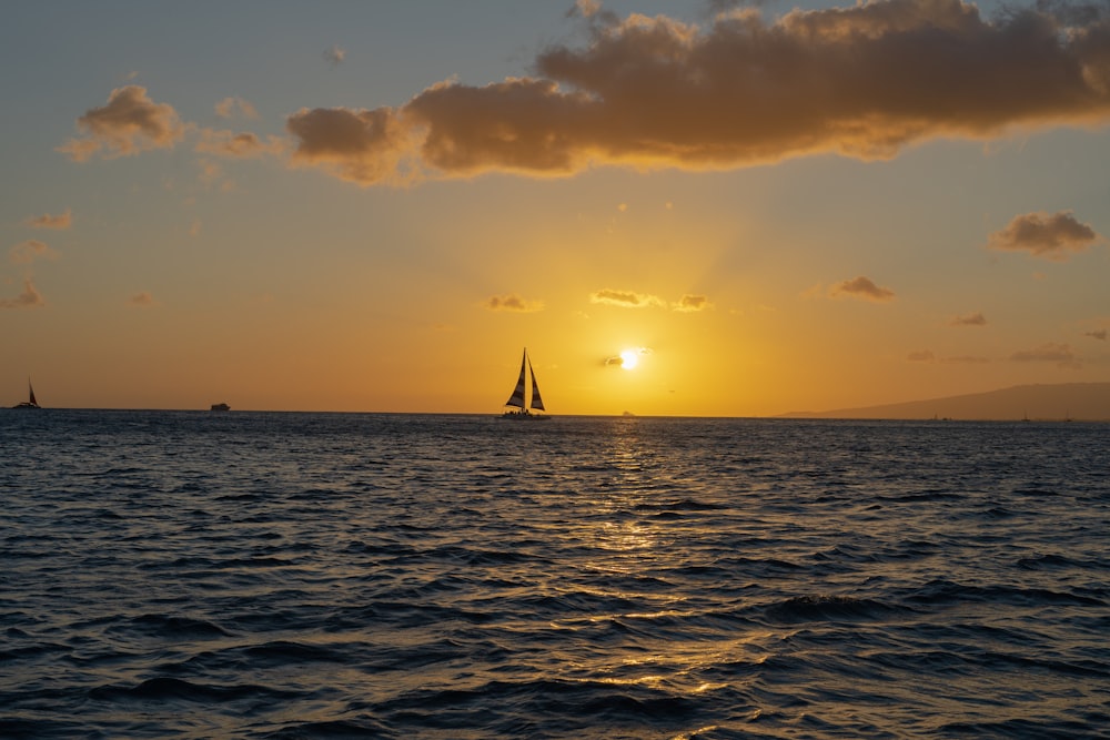 sailboat on sea during sunset