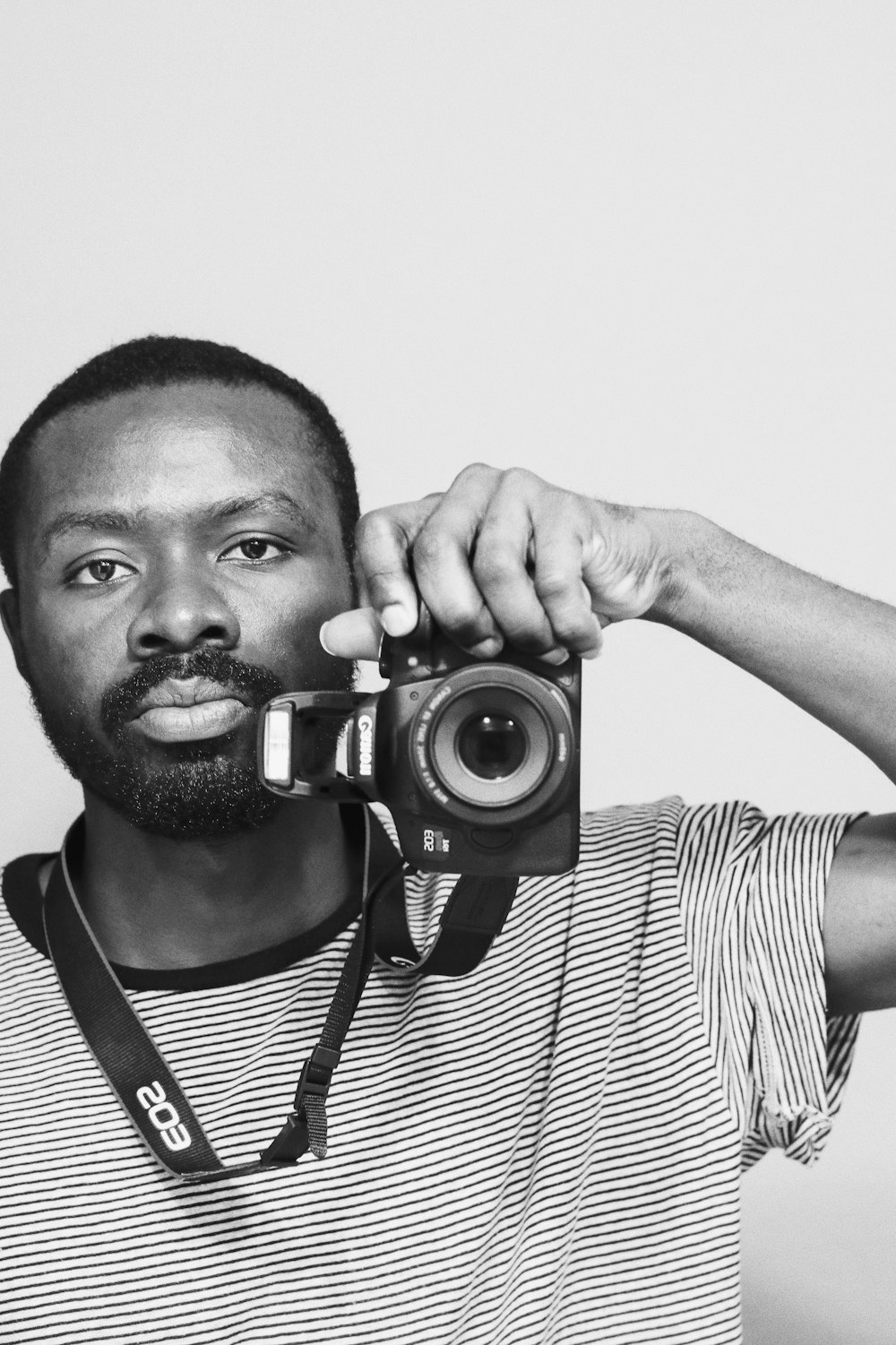 man in striped shirt holding camera