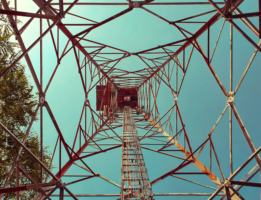 Orange-toned electrical transmission tower under a blue sky near Nyandarua County