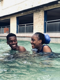 Smiling swimmers cooling down together after a rigorous training session at the poolside.