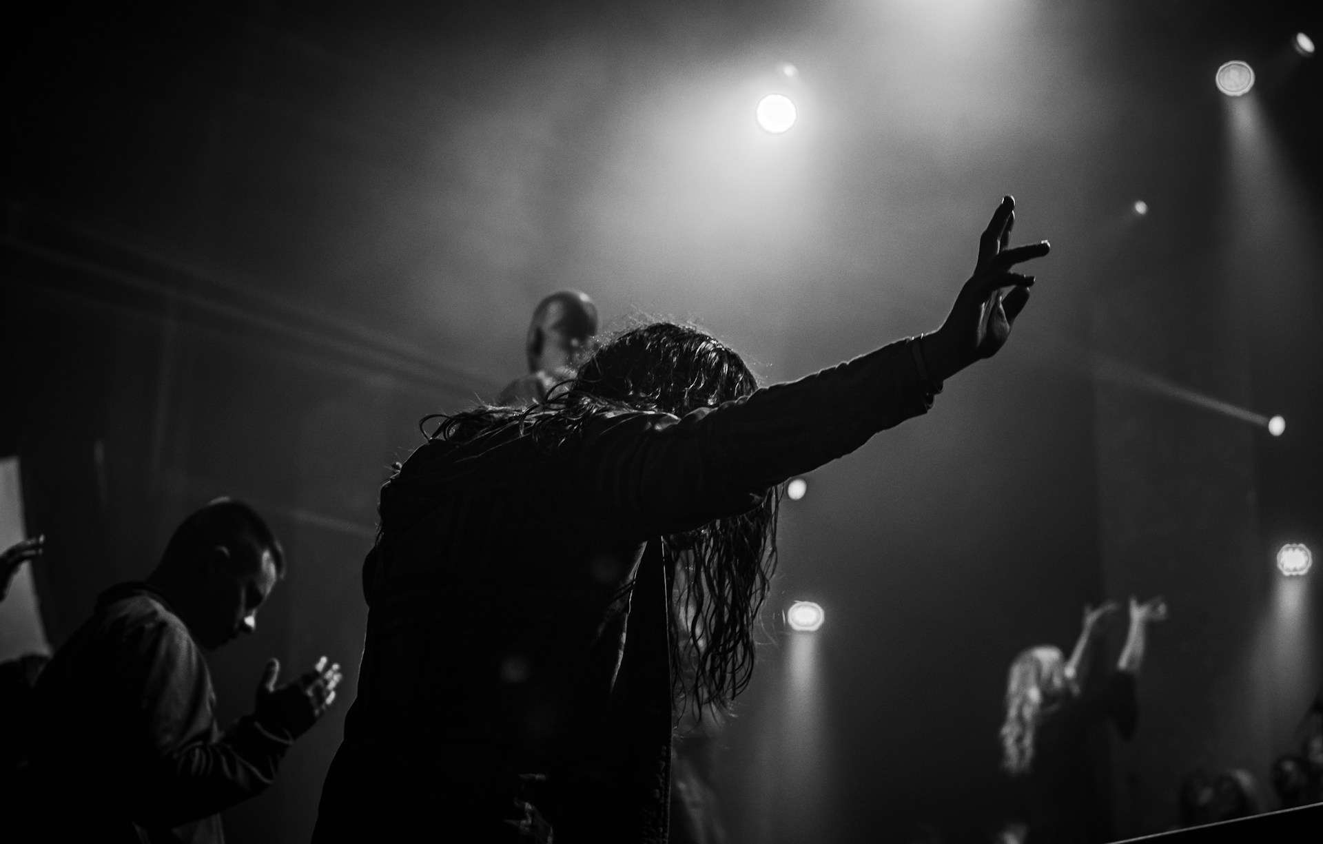 man in black jacket raising his hand