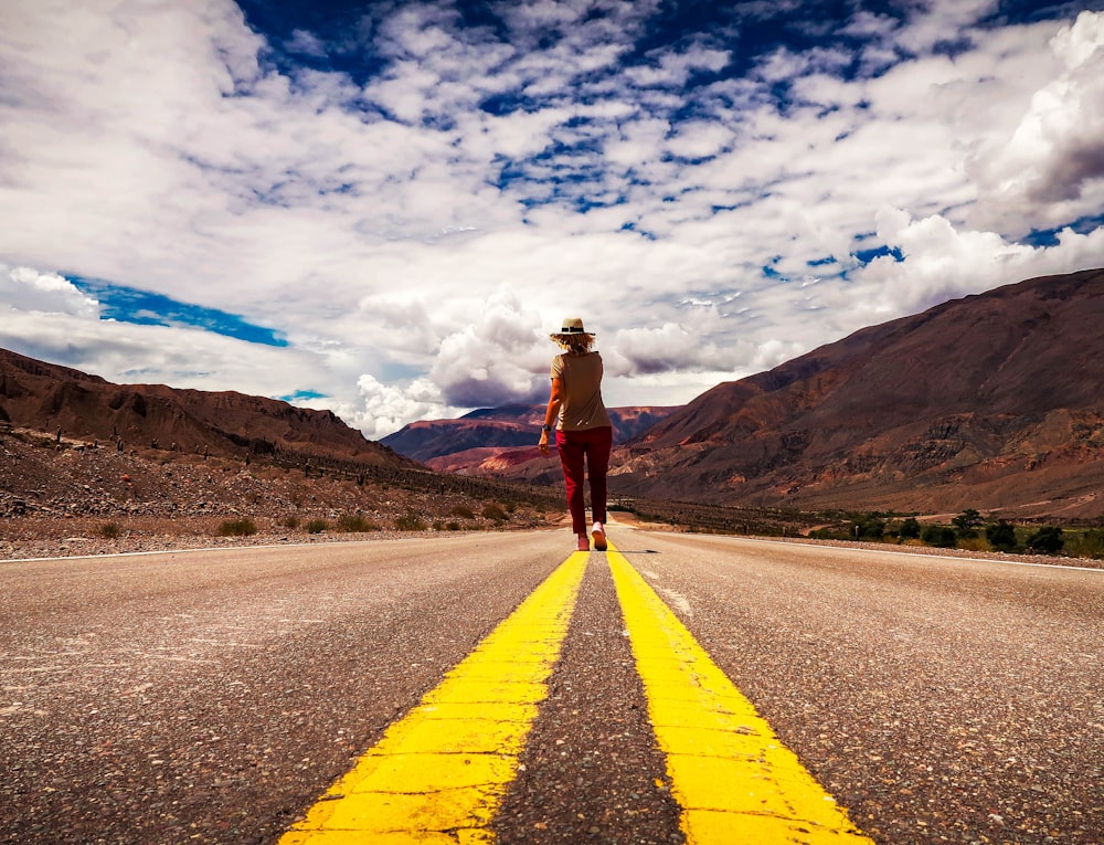 man in brown jacket standing on road during daytime