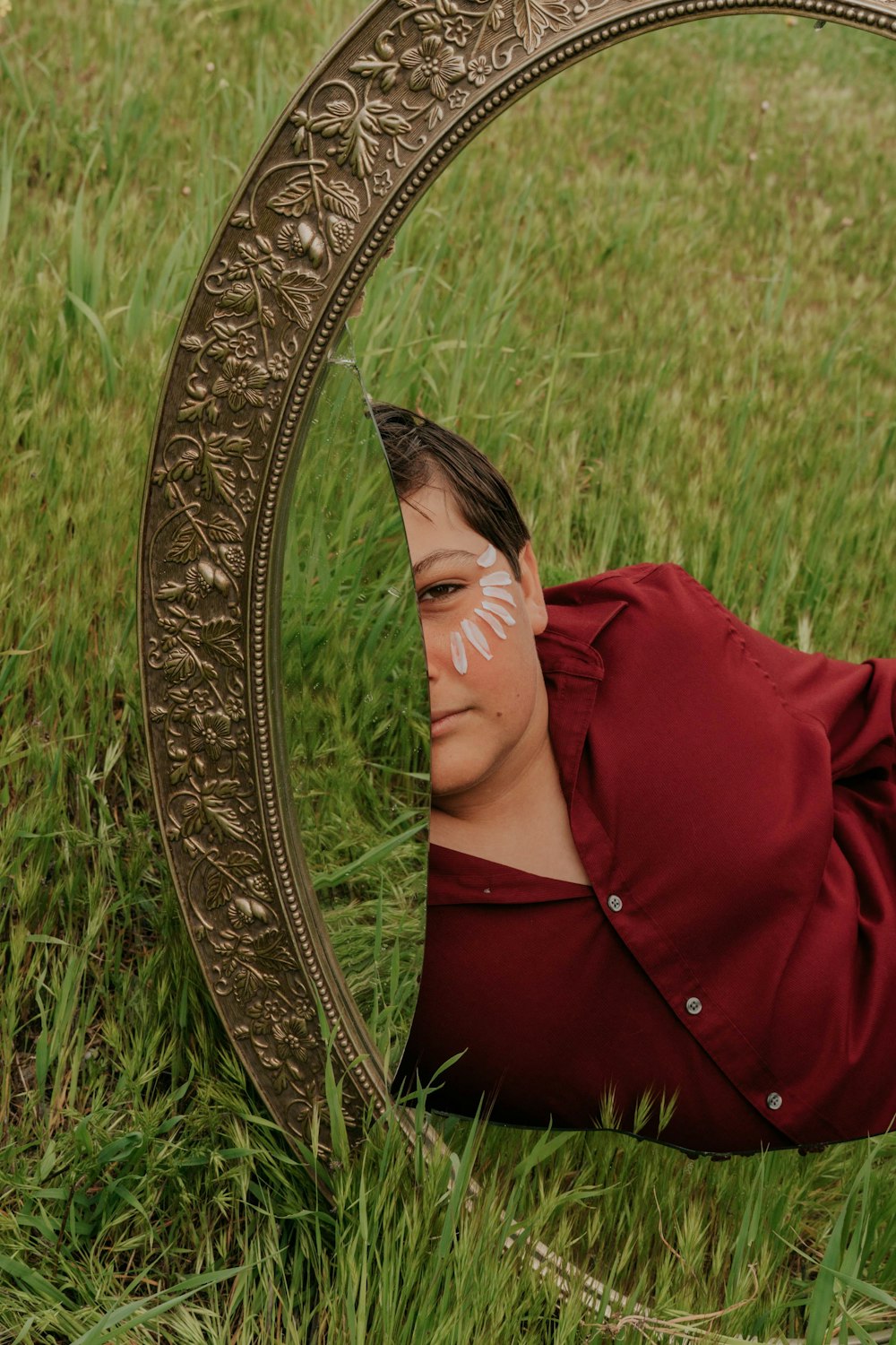 緑の芝生に横たわる赤いブレザーの女性