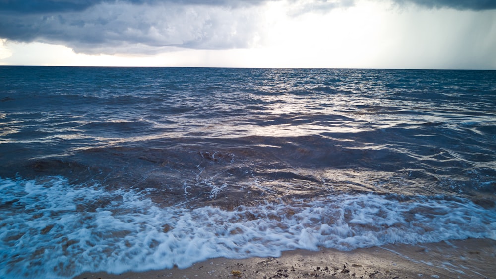 ocean waves crashing on shore during daytime