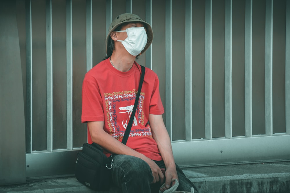 man in red crew neck t-shirt wearing white sunglasses sitting on black chair