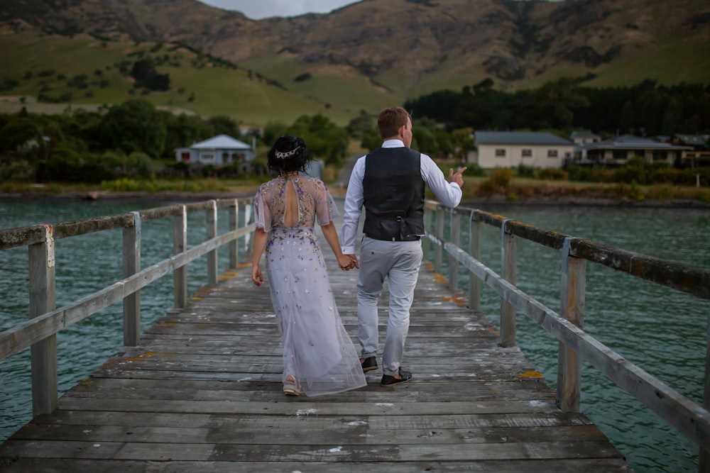 man and woman walking on wooden dock during daytime