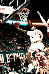 A player skillfully executing a layup in front of an enthusiastic crowd.