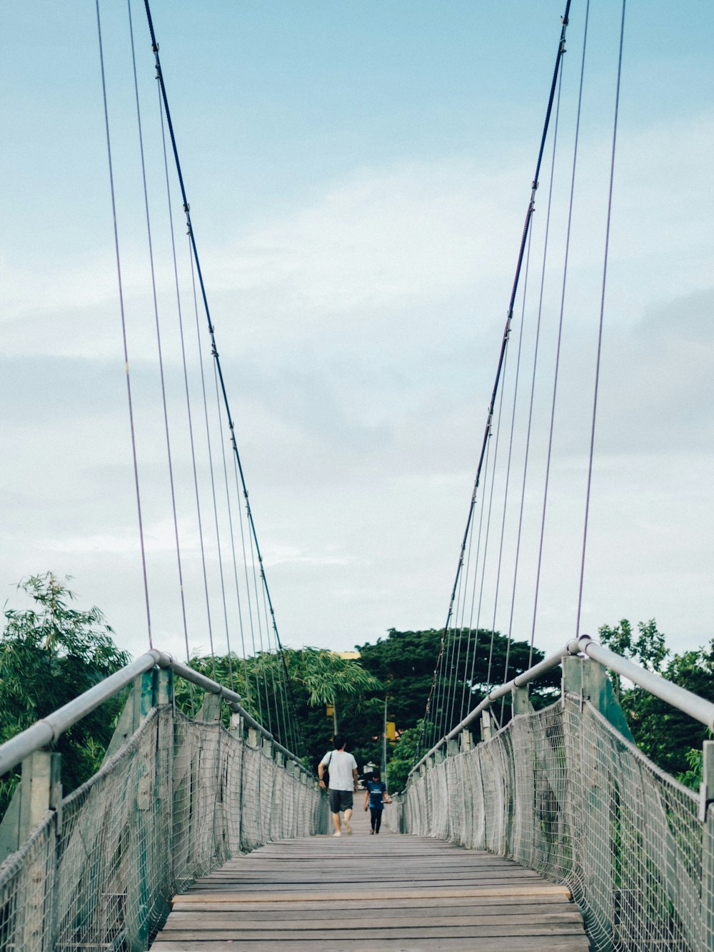 people walking on hanging bridge during daytime