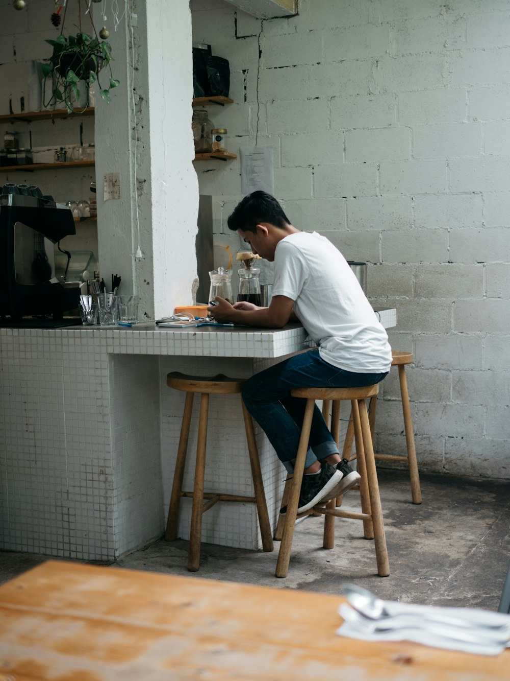 man in white shirt sitting on brown wooden chair