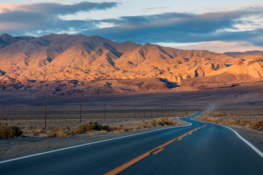 gray concrete road near brown mountains during daytime in Death Valley National Park United States