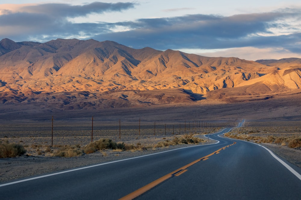 gray concrete road near brown mountains during daytime