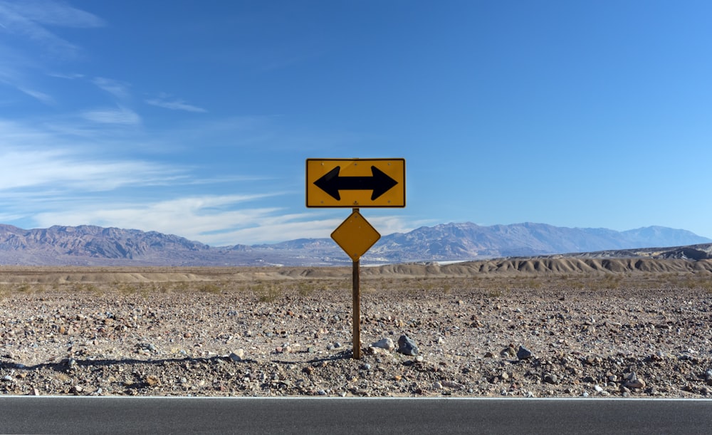 Una señal de tráfico que apunta en direcciones opuestas en el desierto