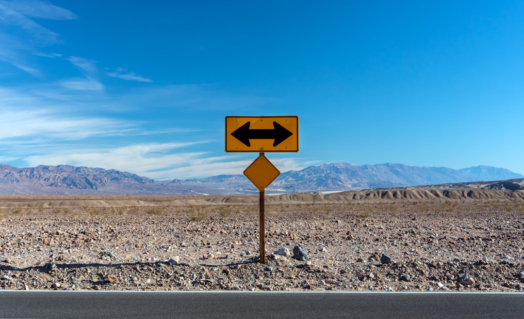a road sign pointing in opposite directions in the desert