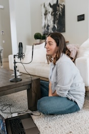 woman in white long sleeve shirt and blue denim jeans sitting on white couch