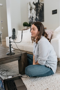 woman in white long sleeve shirt and blue denim jeans sitting on white couch