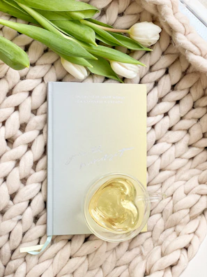 Stack of elegant notebooks tied with a ribbon, placed next to a steaming cup of tea.