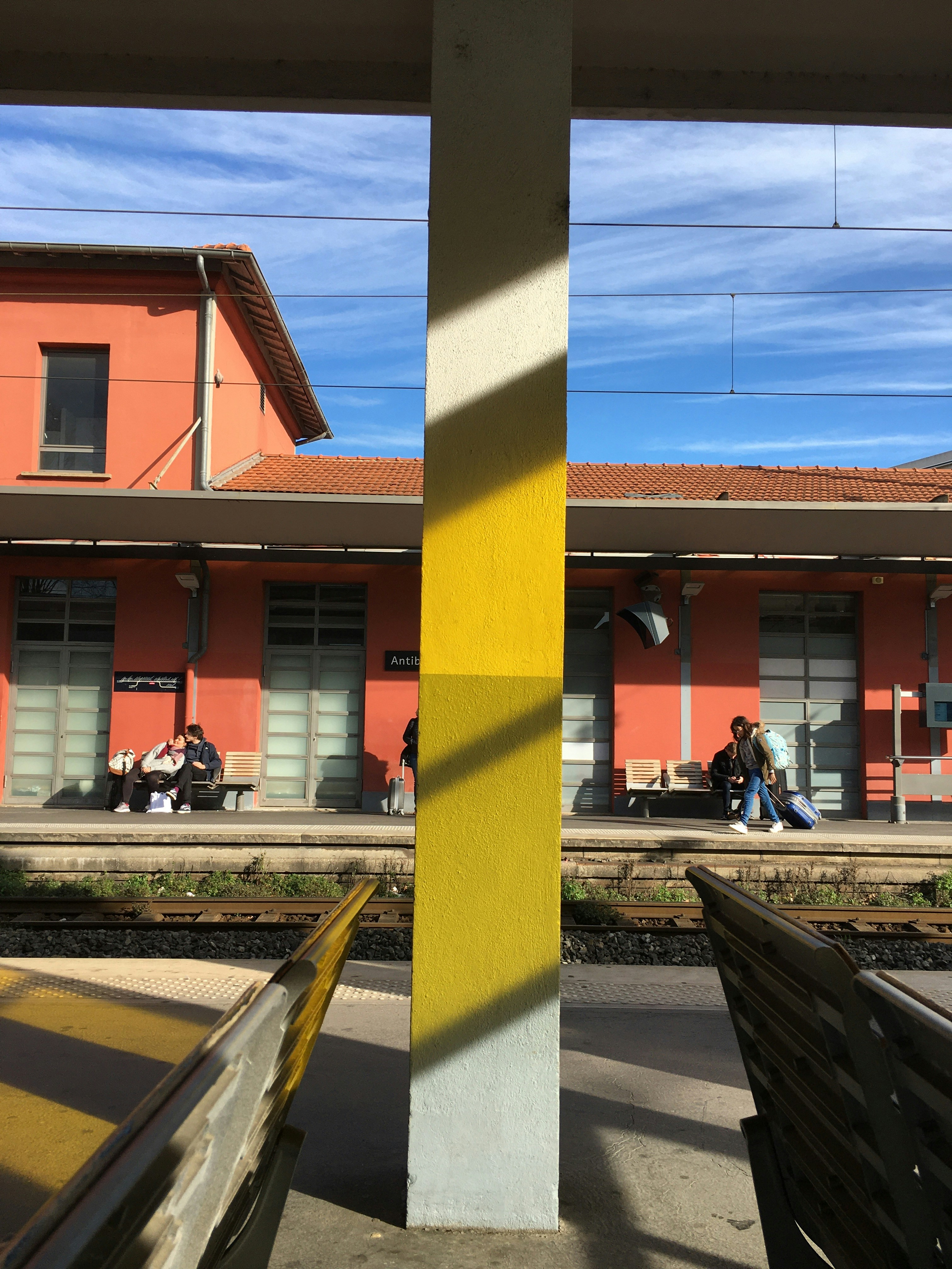 people sitting on bench near brown concrete building during daytime