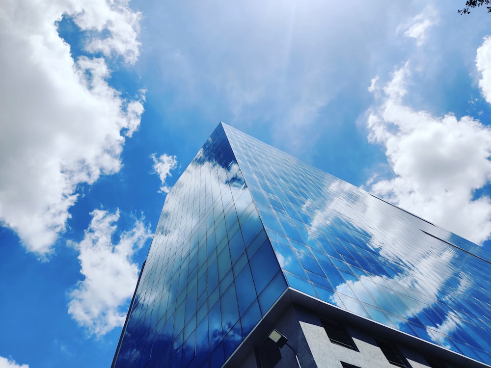 céu nublado azul e branco sobre o edifício de concreto branco e preto