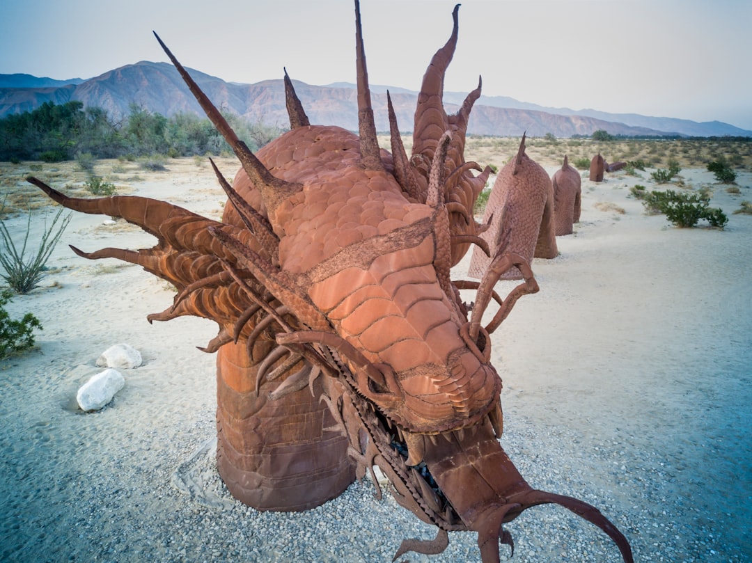 brown wooden animal sculpture on gray sand during daytime