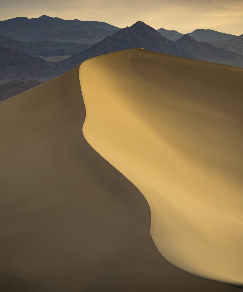 white sand with mountain range in the distance