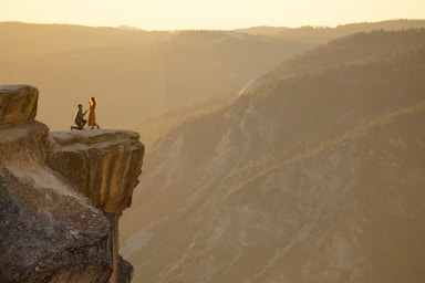 the knee,how to photograph person sitting on rock formation during daytime