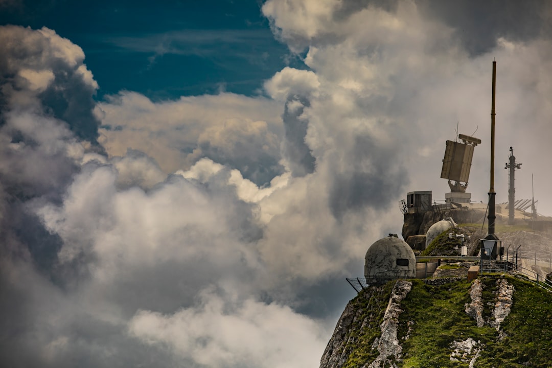 gray concrete building on top of mountain under white clouds during daytime