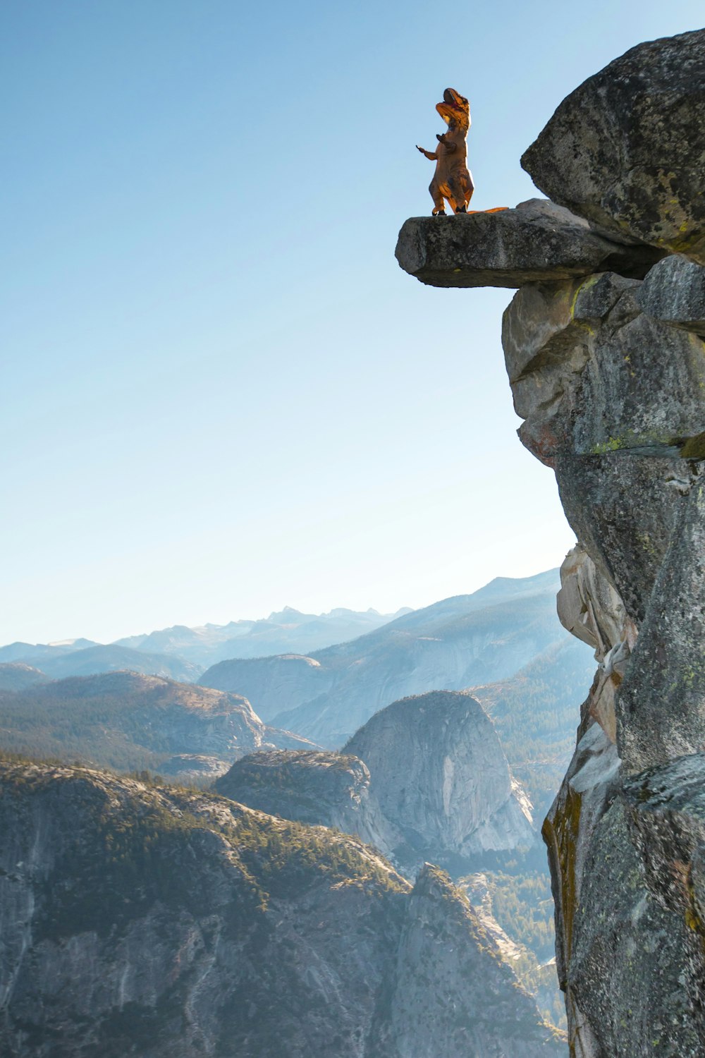 person in black jacket sitting on rock formation during daytime