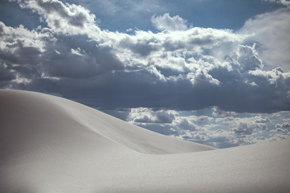 white sand under blue sky and white clouds during daytime