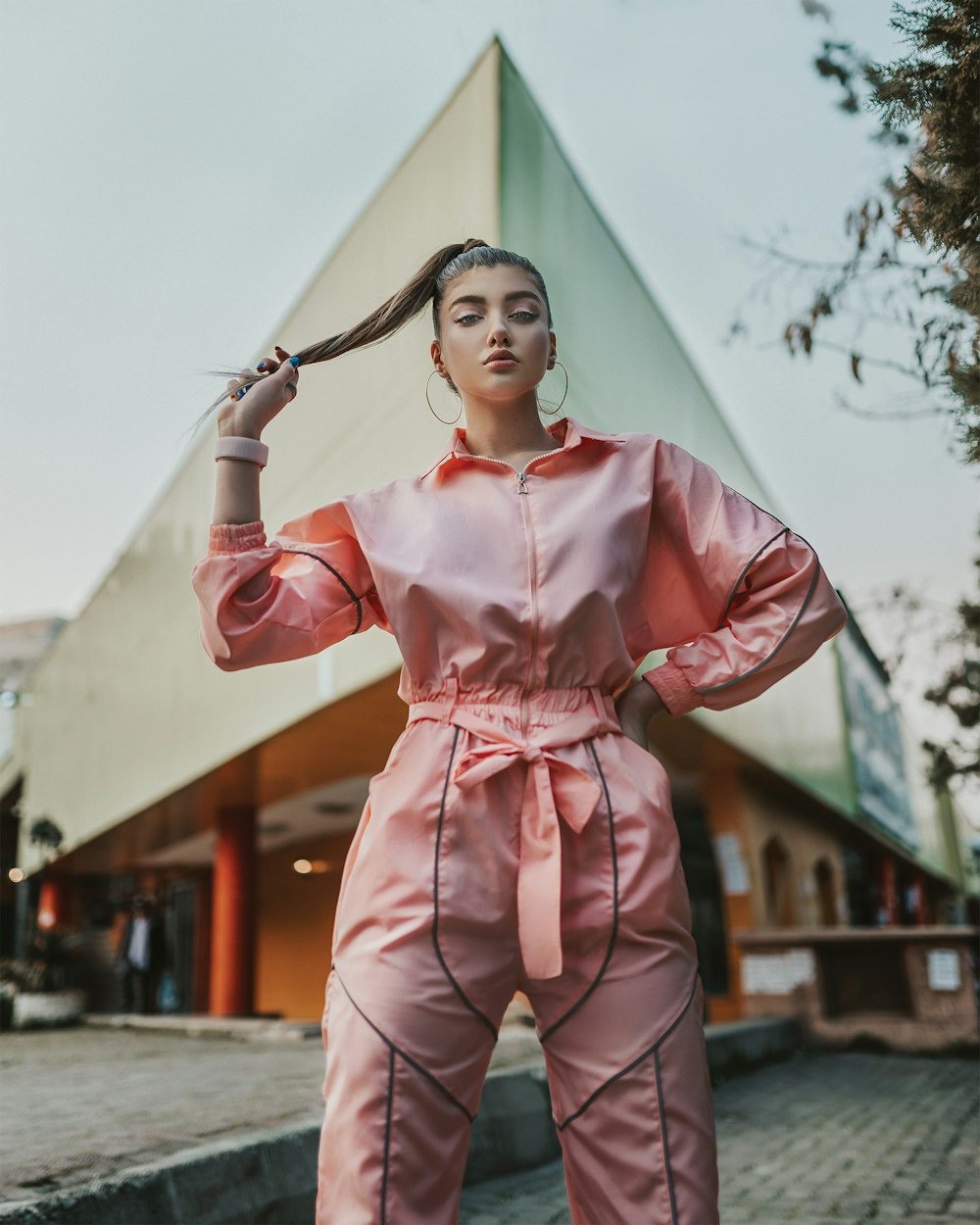 woman in pink long sleeve shirt and pants holding her hair