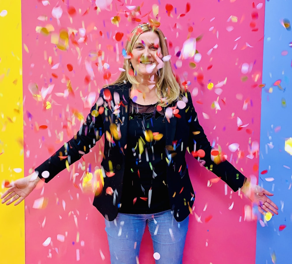 woman in black and pink zip up jacket standing and smiling