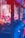 A row of claw machines filled with plush toys is bathed in vivid red and blue lighting. The machines are stocked with colorful stuffed animals, including characters wearing hats. The bright neon lights create a vibrant and slightly surreal atmosphere.