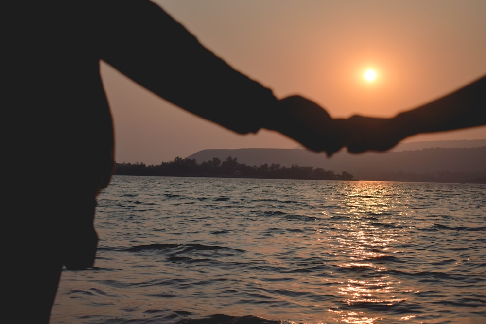 silhouette of person holding sun