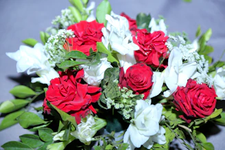 A vibrant hand bouquet featuring fresh roses and lilies arranged by expert florists.
