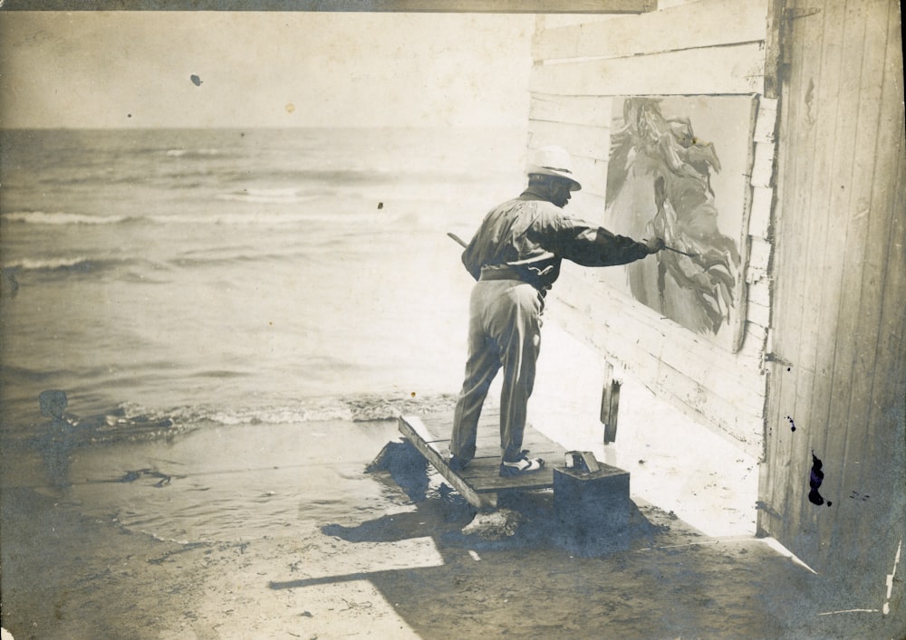 man in gray jacket and pants holding a black shovel