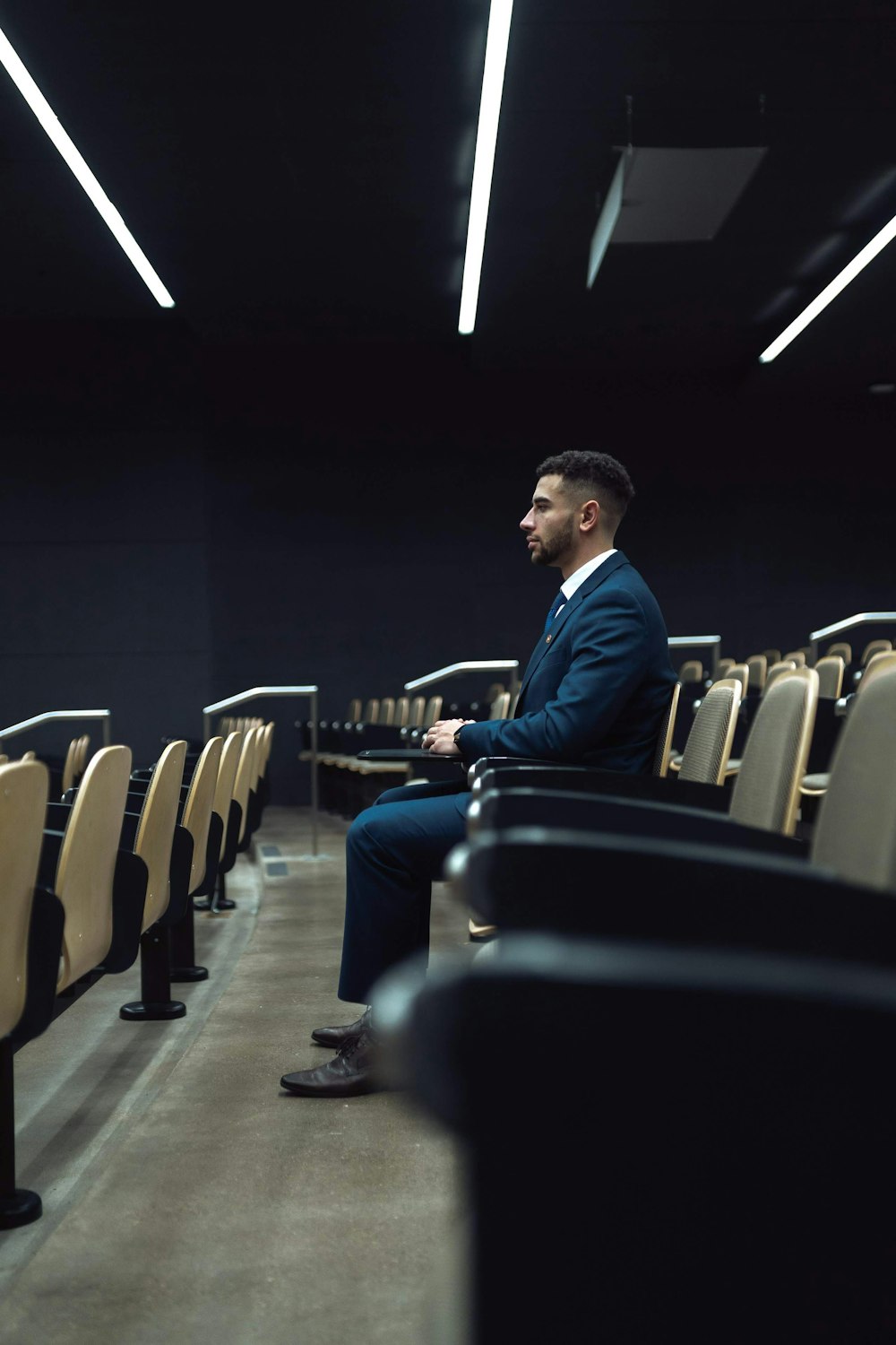 man in blue dress shirt sitting on black chair