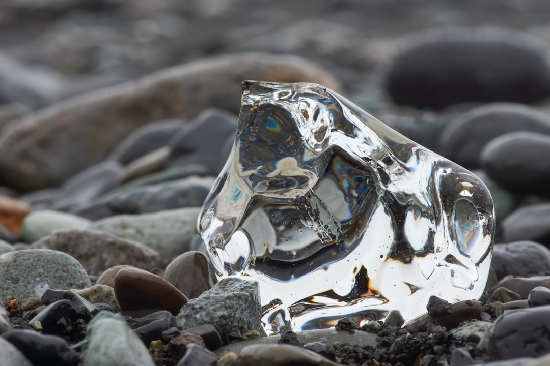 silver and blue heart shaped ring on gray rocks