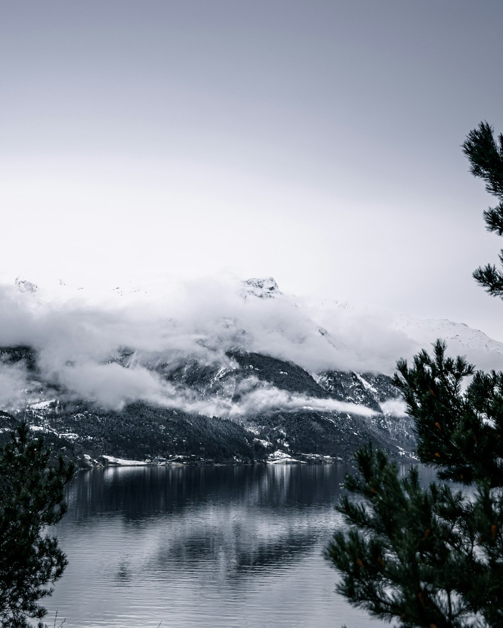 snow covered mountain near lake during daytime