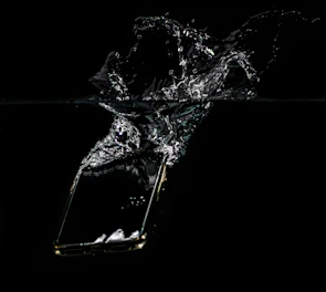 An OtterBox case withstanding a splash of water near a riverbank.