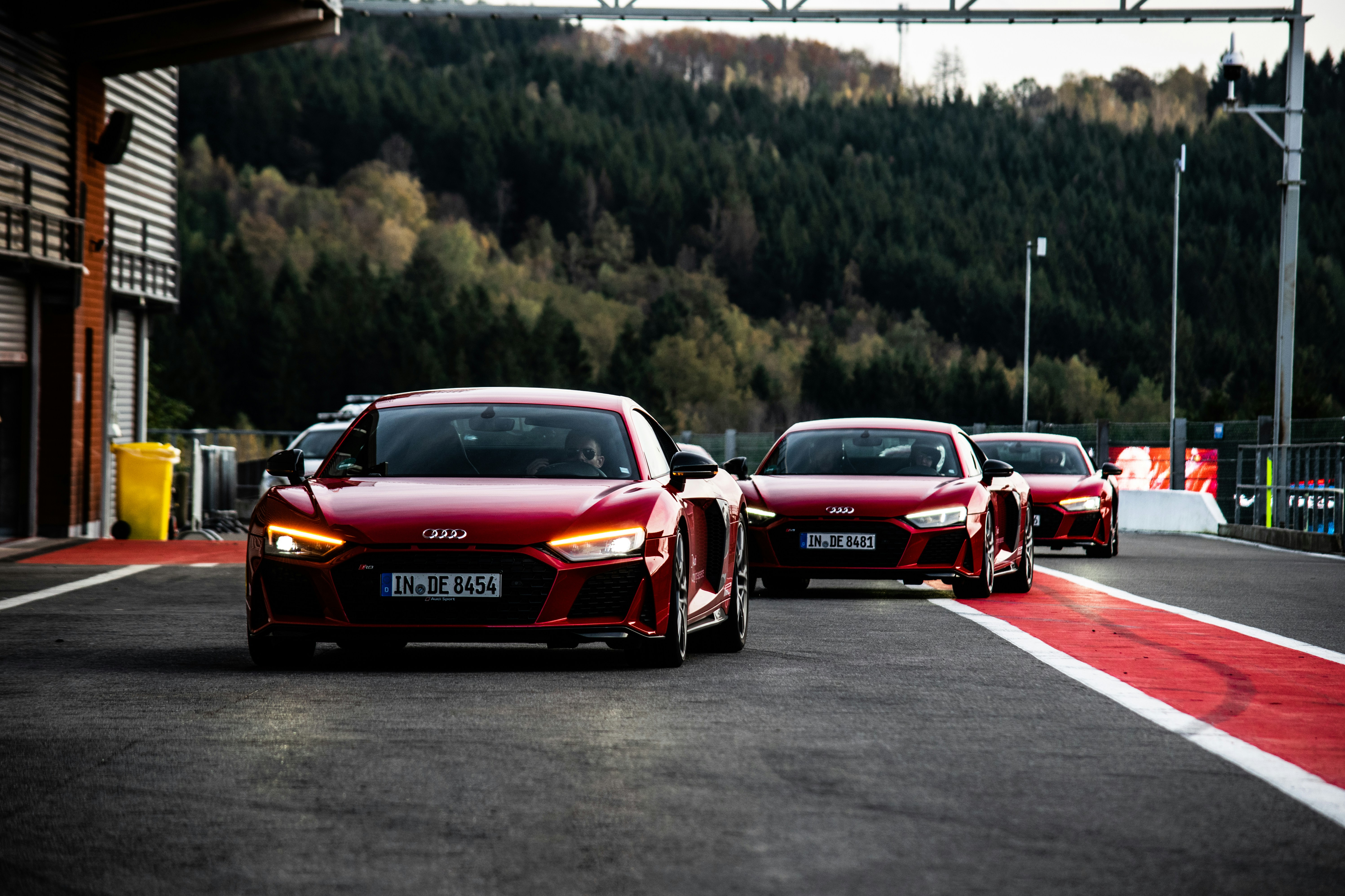 Start a rental car app - Convoy of Audi R8 entering pit lane