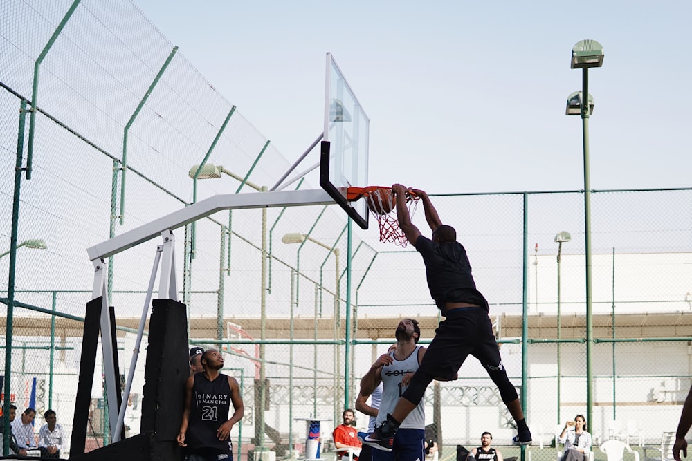 man in black shirt and black pants playing basketball during daytime