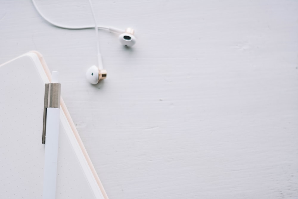 white earbuds on white wooden table