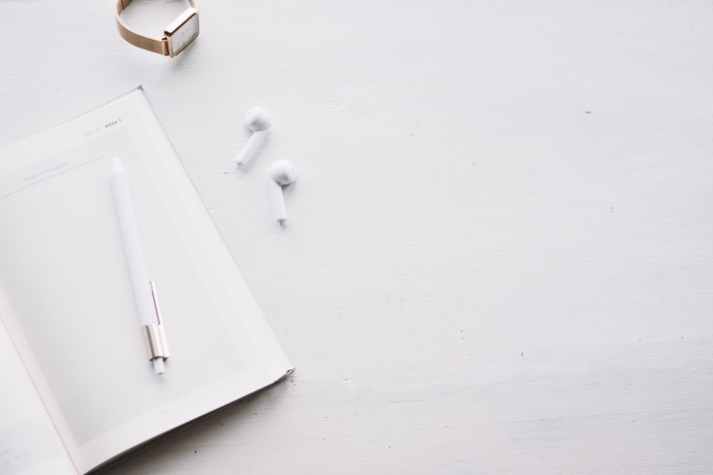 white and gold pen on white wooden table