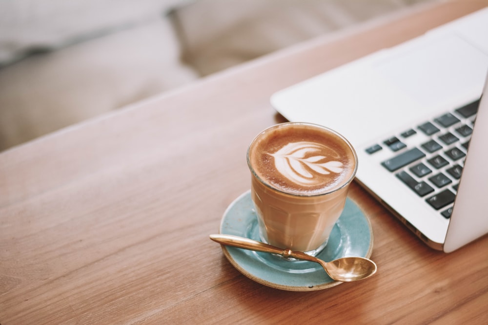 Cappuccino in weißer Keramiktasse auf Untertasse