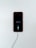 A smartphone with a red exterior is connected to a charging cable. The phone's screen displays a low battery icon with a charging symbol beneath it, indicating that the device is in the process of recharging.