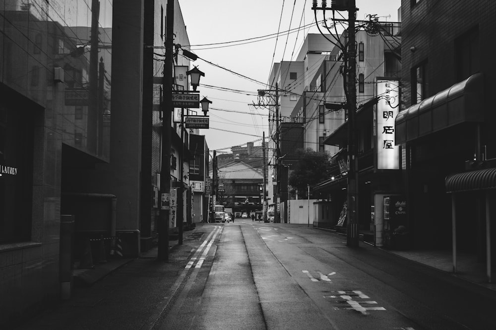 grayscale photo of empty road between buildings