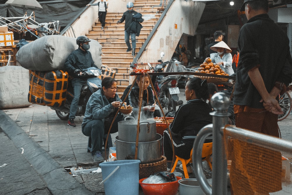 people in blue jacket sitting on gray concrete floor during daytime