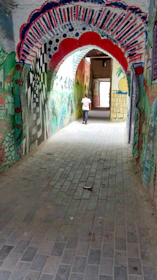 An intimate moment of a visitor admiring a tucked-away historic mural in a quiet alley.