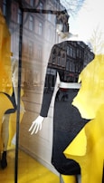 Classic white mannequin posed elegantly in a boutique window.